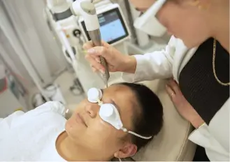 A medical professional performing a Fotona ablative fractionated laser treatment on a patient wearing eye protection.