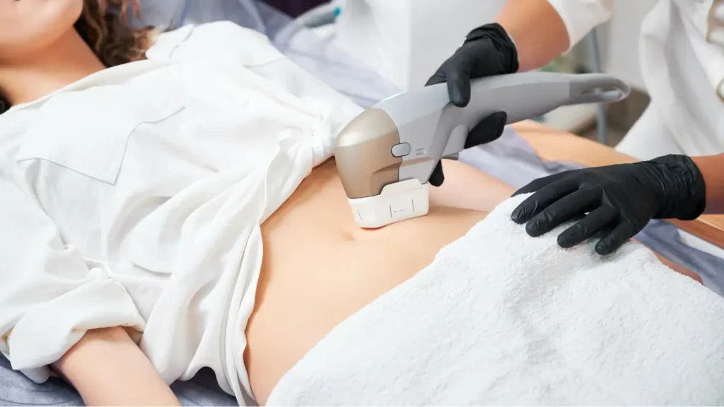 A clinician using a body contouring device on a woman's stomach during a professional treatment session at a Melbourne clinic