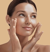 Woman touching her face with smooth glowing skin representing Fotona 5D laser skin treatment results