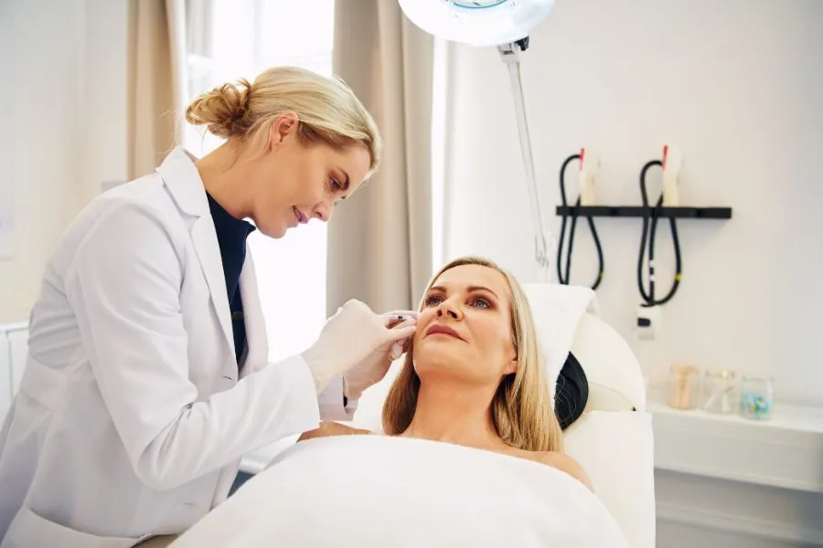 Experienced professional administering a cosmetic procedure with a focus on facial anatomy and client safety.