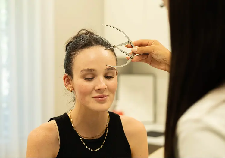 Clinician measuring facial structure before aesthetic treatment in Melbourne