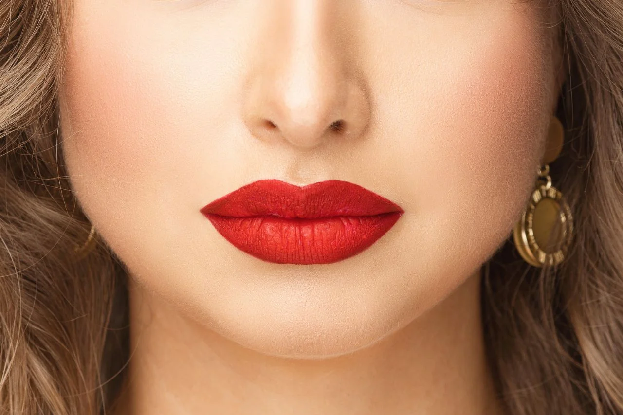 What is russian lip technique: A close-up of a woman with red lipstick showing the increased height and flat profile associated with the vertical placement method.