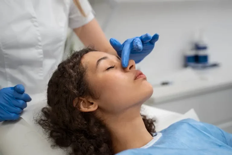 Clinician examines a patient’s nose during a consultation explaining what a nose thread lift is