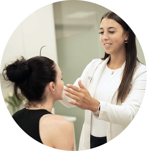Cosmetic clinician assessing a client’s face during personalised treatment consultation in Melbourne
