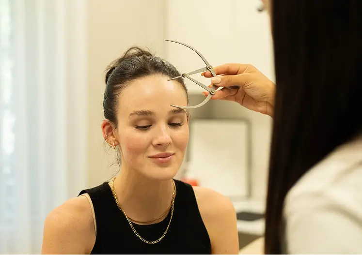 Cosmetic practitioner measuring facial proportions during a consultation for lip injections in Melbourne