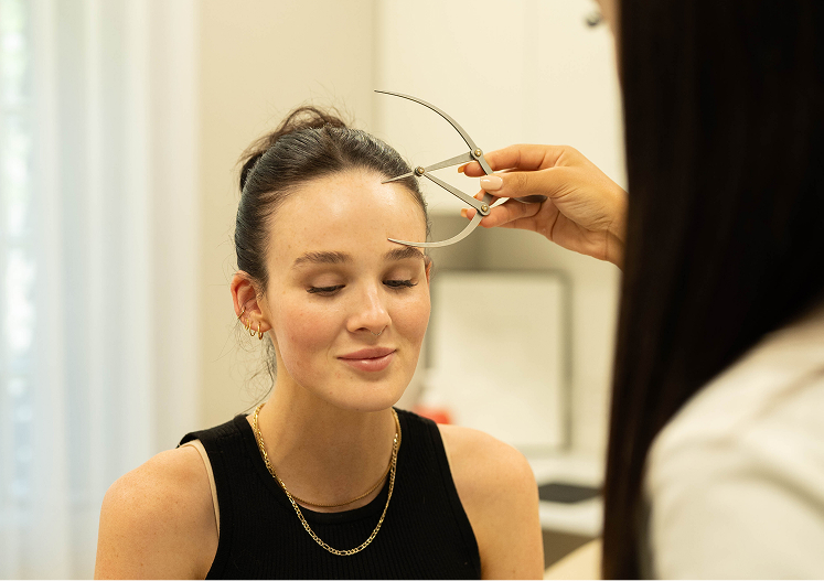 Clinician measuring facial structure before PDO thread lift treatment in Melbourne