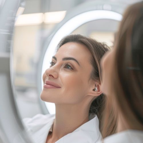 A woman looking in a mirror at her smooth, rejuvenated skin after a Morpheus8 treatment at Luxe Lips, demonstrating the clinical results of radiofrequency microneedling.