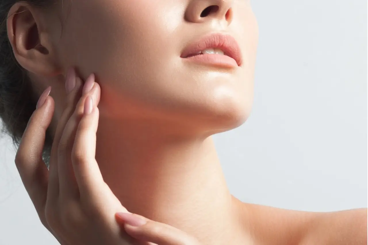 Close-up of smooth neck and jawline with hand touching skin, showing results for which Rejuran is best treatments
