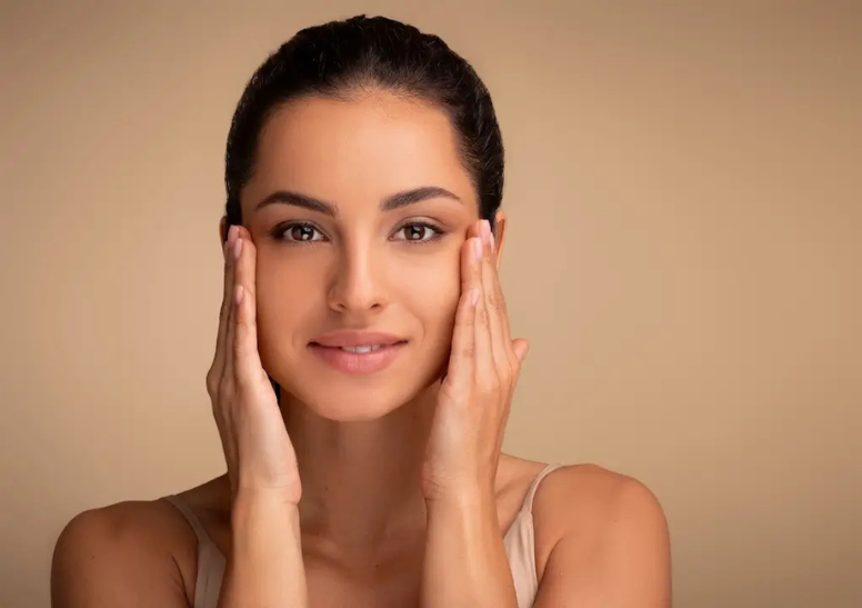 Woman touching her face with smooth, firm skin representing results and aftercare following Forma skin tightening treatment