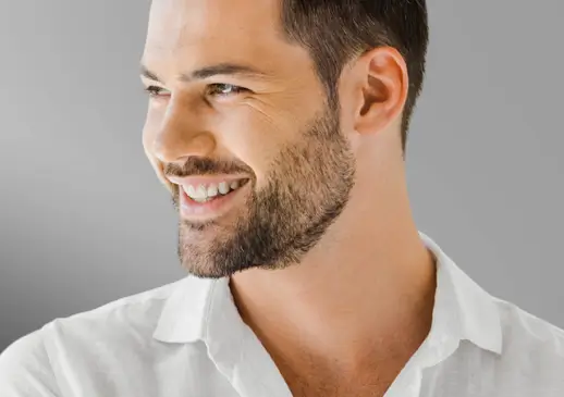 Relaxed man in a white shirt smiling, representing men's energy and recovery care