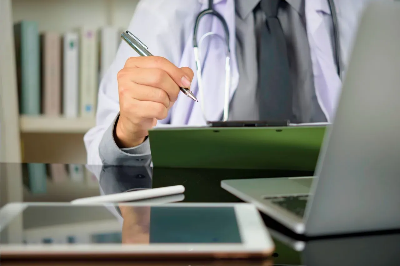 Medical professional reviewing notes at a desk, representing the clinical assessment needed to determine facial thread lift cost