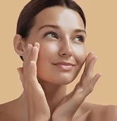 Woman touching her face with smooth glowing skin representing Fotona 5D laser skin treatment results